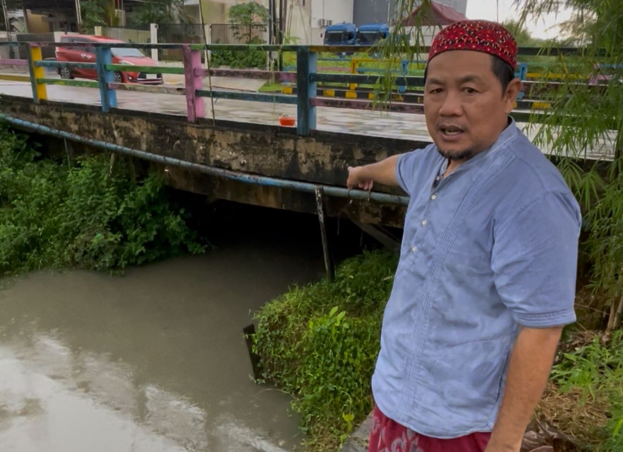 Ketua RT 30 Sempaja Selatan menunjukkan titik aliran anak Sungai Perjuangan yang kerap dipenuhi sampah plastik dari kawasan GOR Kadrie Oening, terutama usai hujan dan air pasang.